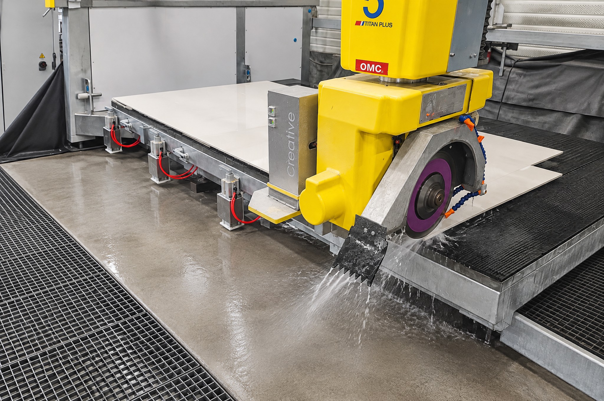 De brugzaag zaagt een keramiek plaat met water